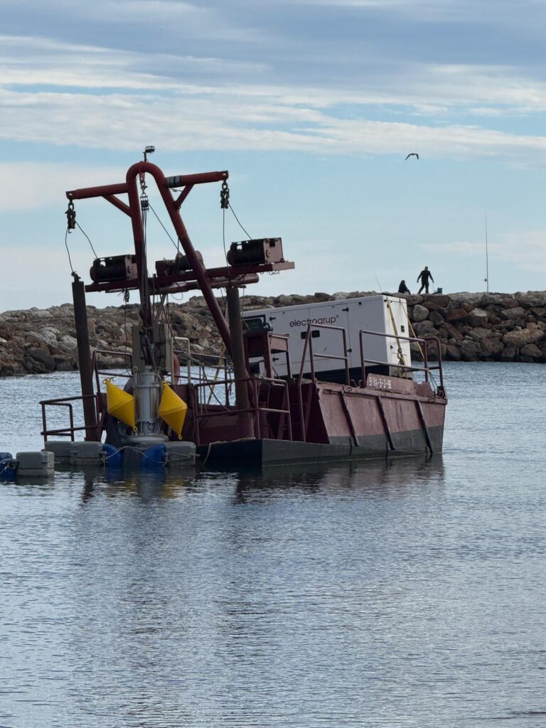Pontón de dragado trabajando junto a la escollera